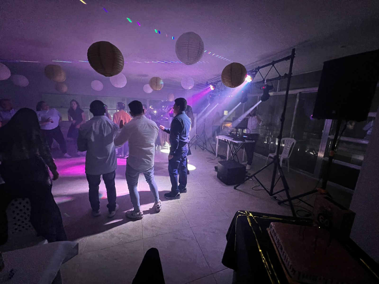 Invitados bailando bajo luces violetas y cabezas móviles