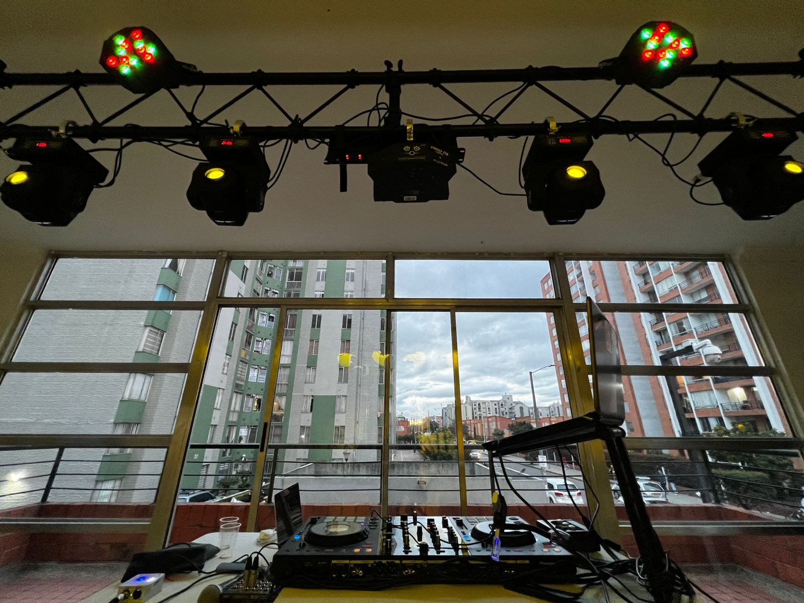 Cabezas móviles sobre la cabina de DJ frente a un ventanal
